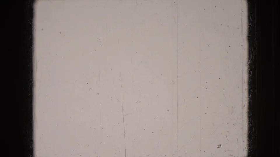 Blank or overexposed 8mm frame from the 1966 Athens, Ohio home-movie clip, with visible scratches, dust, and dark gate edges.