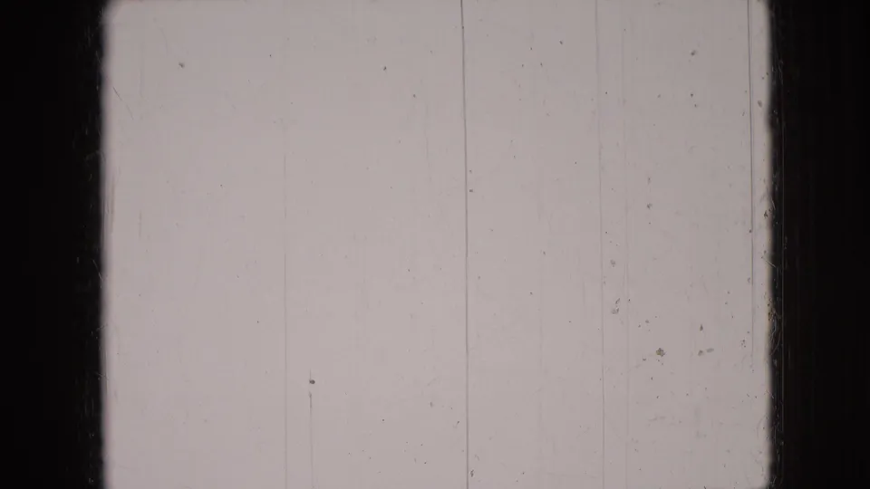 Pale scratched 8mm frame from the metadata-supported 1966 Athens, Ohio clip, showing film wear before the dog scene appears.
