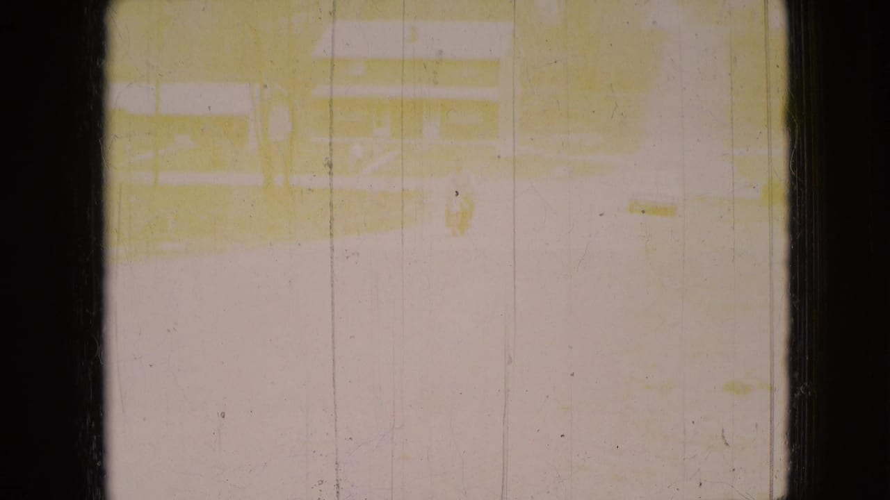 The second frame is heavily overexposed and yellowed, with only faint traces of the residential road and house scene visible through scratches and dust.