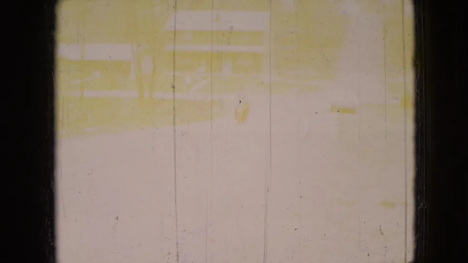 The second frame is heavily overexposed and yellowed, with only faint traces of the residential road and house scene visible through scratches and dust.