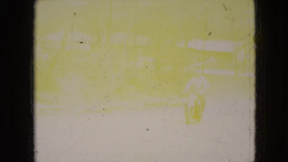 The final frame is strongly faded and yellow, with a faint motorcycle rider shape near the lower right and barely visible traces of the residential street scene.
