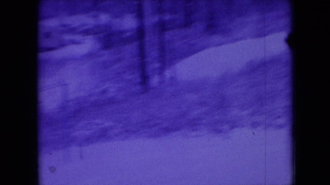 Blue-tinted 1966 8mm home-movie view in Athens, Ohio, showing a snowy yard, bare trees, and a winding path with dark film borders.