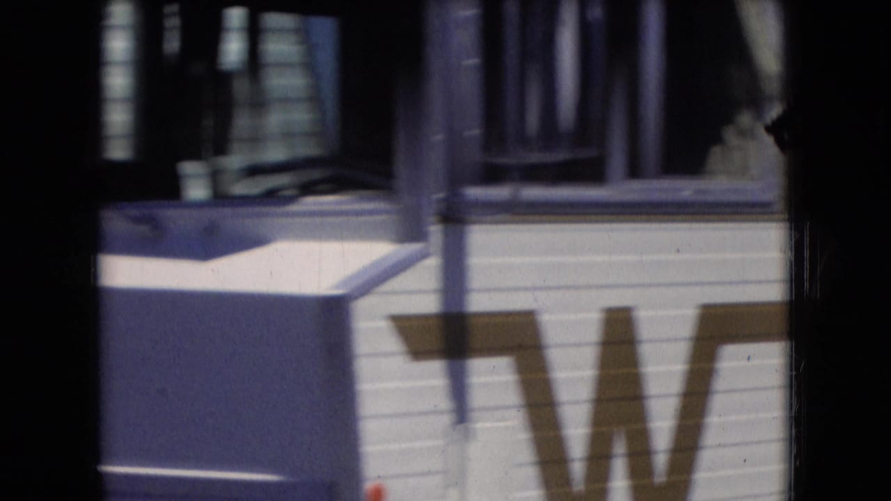 Side of a white RV with windows and a partial large W marking.
