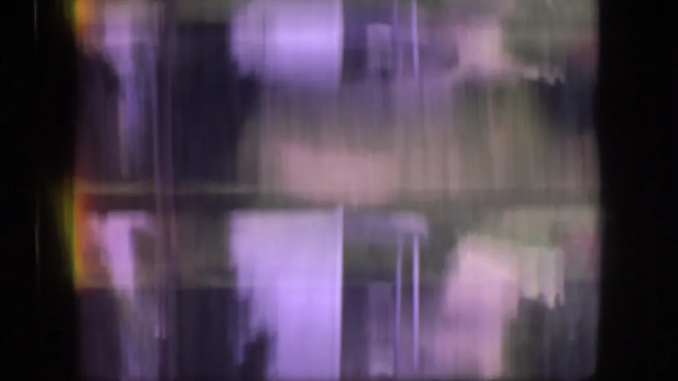 Soft, motion-blurred 8mm frame with vertical streaking and indistinct outdoor forms during a transition between scenes.
