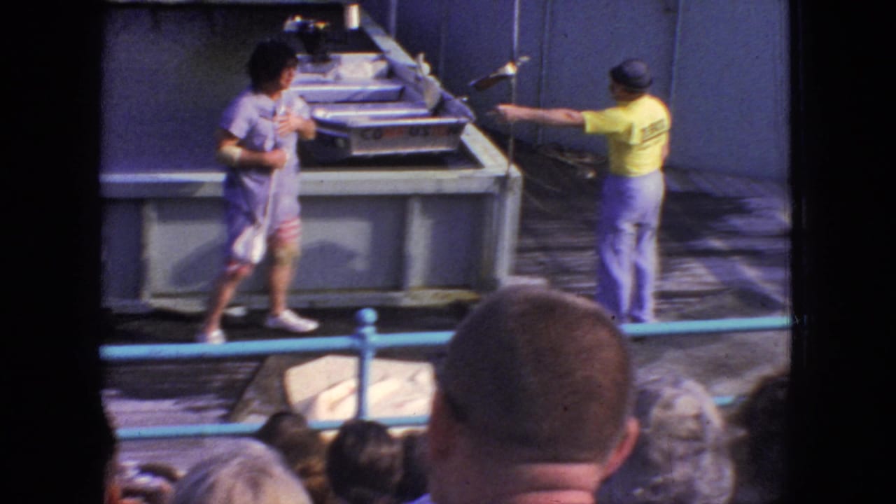 1966 8mm Atlantic City footage shows a visitor's view of a Steel Pier poolside performance, with a woman performer near the tank and an audience head in the foreground.
