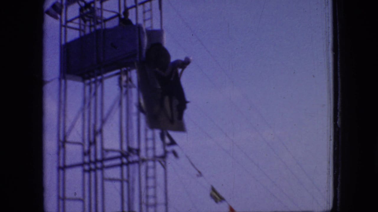 Horse and rider descending from a high scaffold beside the dive ramp.