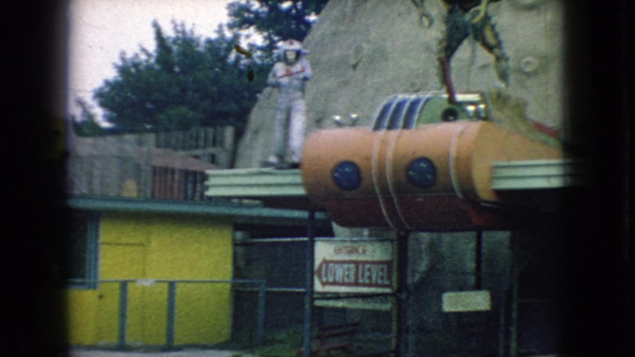 1966 New Jersey 8mm frame showing a colorful novelty building facade with a large sculptural figure, painted surfaces, yellow railing, and partially visible signage.