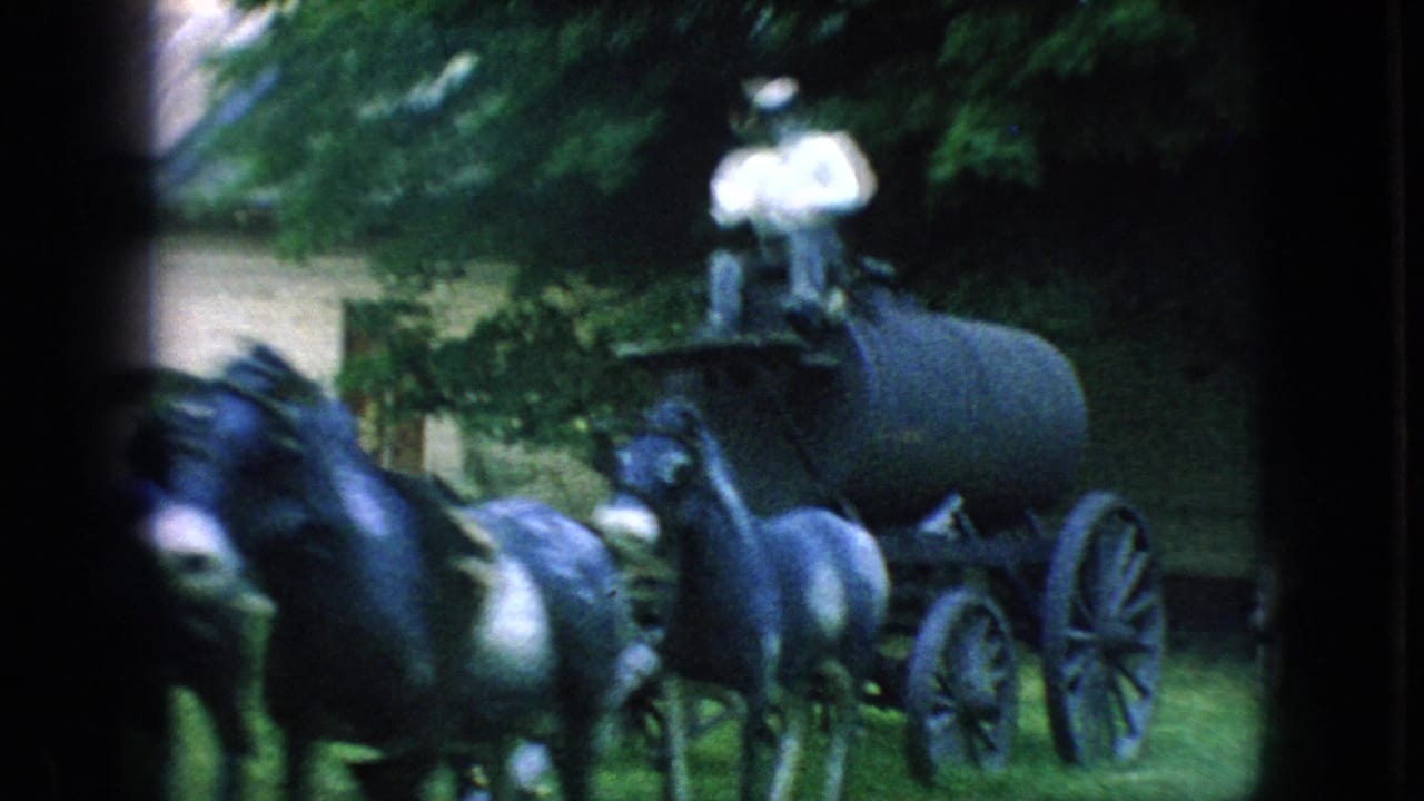 The mule-drawn cart moves closer in the 1966 New Jersey home-movie frame, with the rider above the cart and dark mules filling the foreground.
