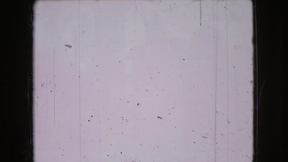 A nearly blank 8mm frame from the 1966 Ohio home-movie sequence, marked by pale exposure, dust spots, vertical scratches, and aged film borders.