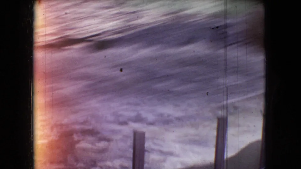 A blurred closing frame of the water-tank attraction shows foamy water, vertical posts, dark edges, and strong color fading from the 8mm scan.