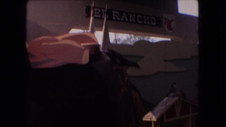 1966 Ohio 8mm frame showing the El Rancho sign, show building details, and a dimly lit aquatic attraction area near the pool.