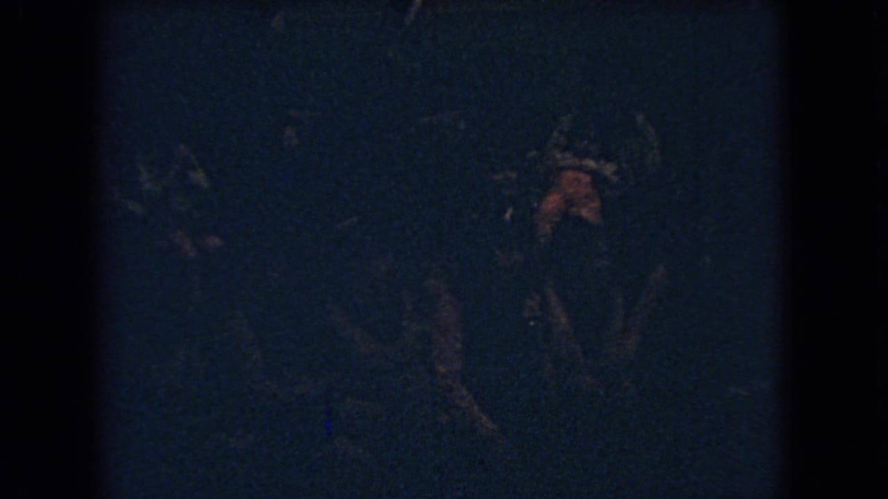 Very dark basketball action with a player shape near the right side of the frame.