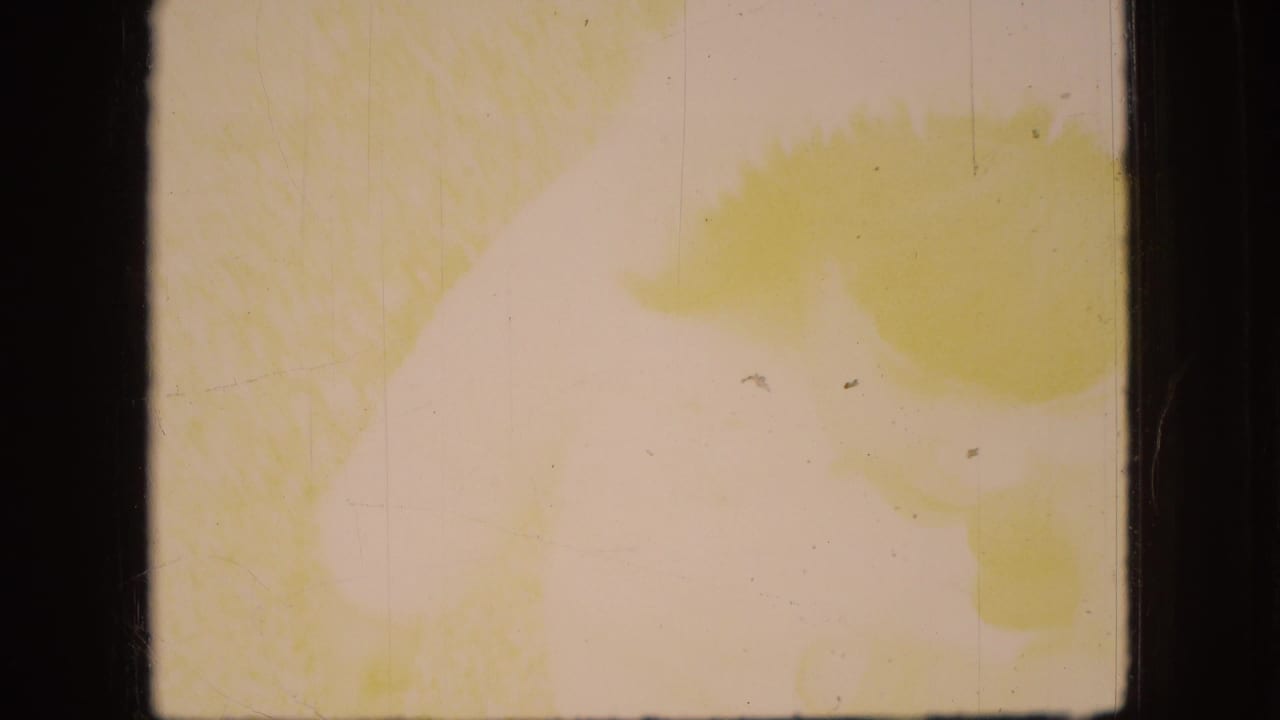A heavily faded 8mm frame from the 1966 Ohio clip shows yellow staining, pale exposure, scratches, and little readable scene detail.