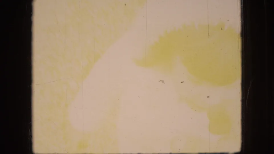 A heavily faded 8mm frame from the 1966 Ohio clip shows yellow staining, pale exposure, scratches, and little readable scene detail.