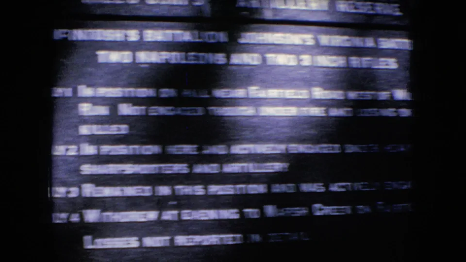 Soft, handheld 8mm frame showing a dark Civil War interpretive plaque with mostly blurred white text and horizontal streaking.