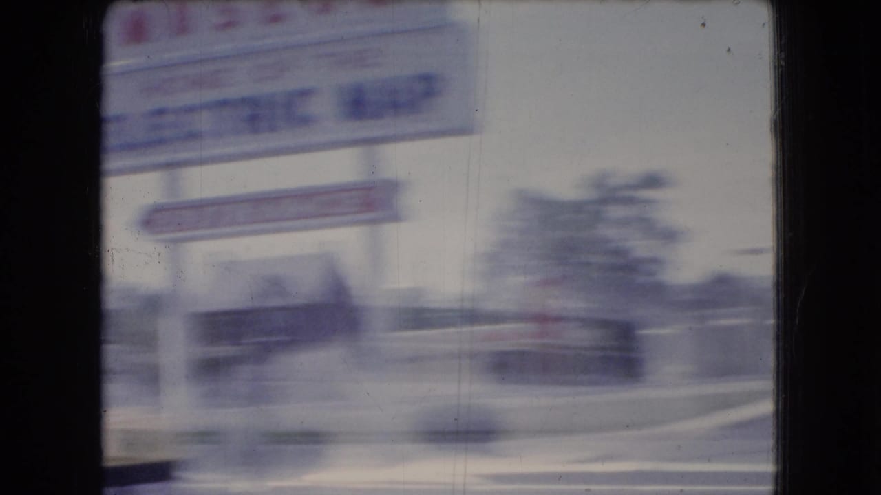 Gettysburg National Museum sign and roadside structures blurred by vehicle movement.