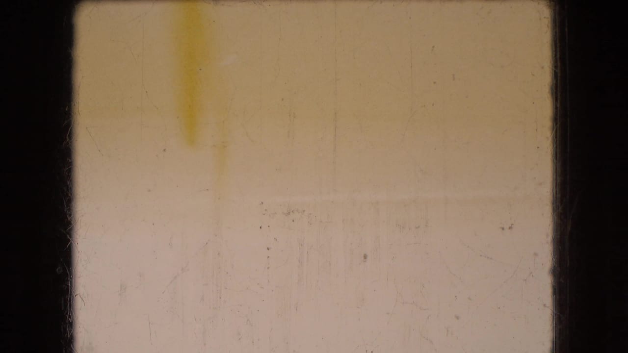 1966 Ohio 8mm home-movie frame dominated by pale yellow exposure, dark gate edges, dust, and scratches with no clear subject identifiable.