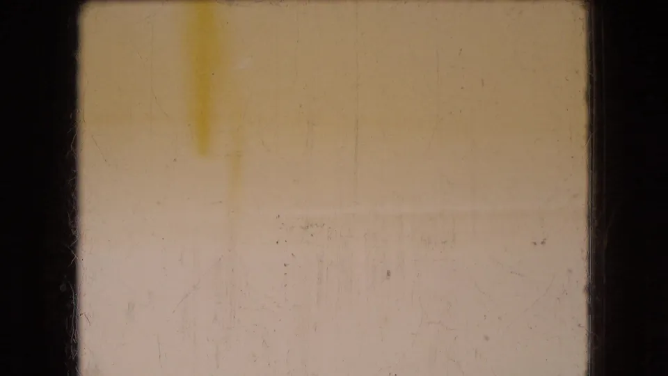 1966 Ohio 8mm home-movie frame dominated by pale yellow exposure, dark gate edges, dust, and scratches with no clear subject identifiable.