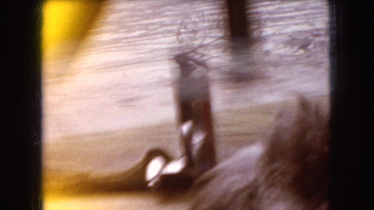 Soft, motion-blurred 1966 Ohio roadside frame with a small structure or vertical post seen through heavy camera movement.