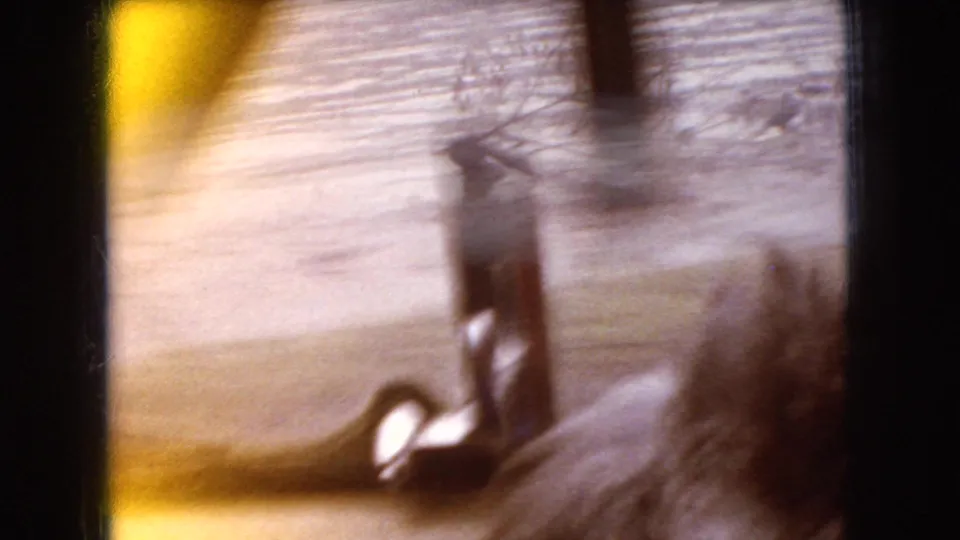 Soft, motion-blurred 1966 Ohio roadside frame with a small structure or vertical post seen through heavy camera movement.