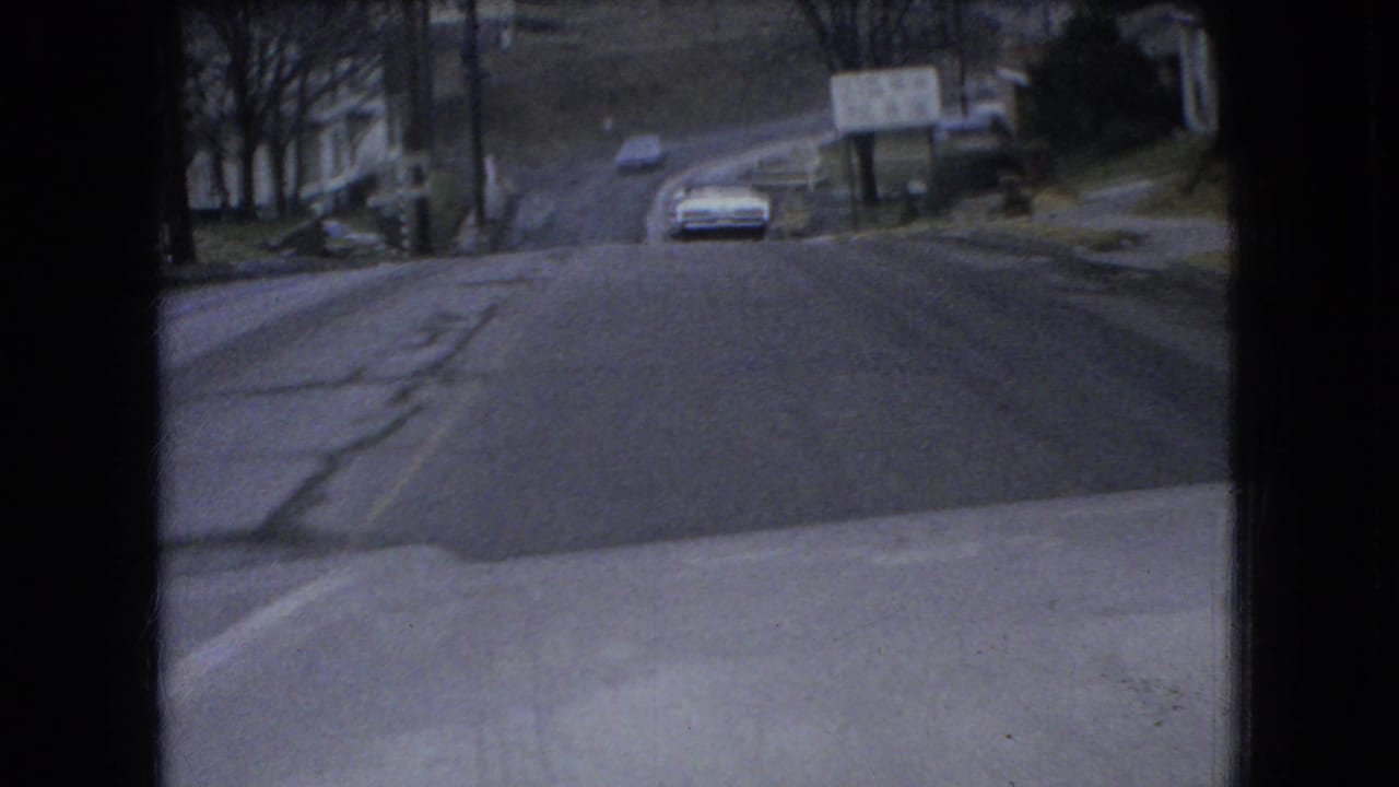 Car approaching on an icy road viewed from inside a vehicle.