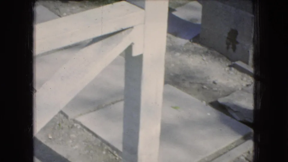 A 1966 Ohio 8mm frame shows concrete steps or a walkway at the edge of a residential outdoor space, with dark film borders and soft exposure.