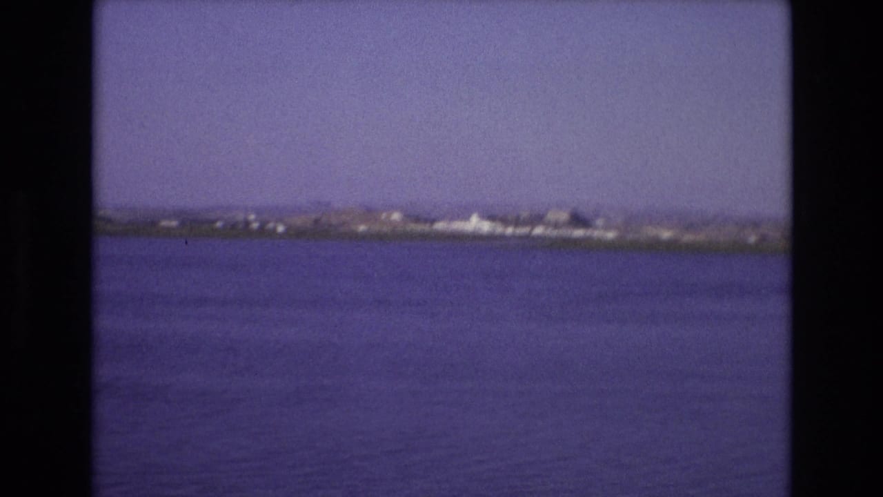 Portugal 1972 8mm frame showing open water, a low distant shoreline, and soft home-movie exposure before the ferry enters the view.