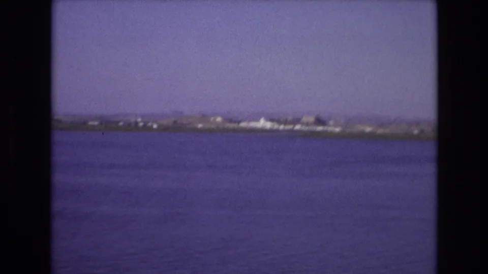Portugal 1972 8mm frame showing open water, a low distant shoreline, and soft home-movie exposure before the ferry enters the view.