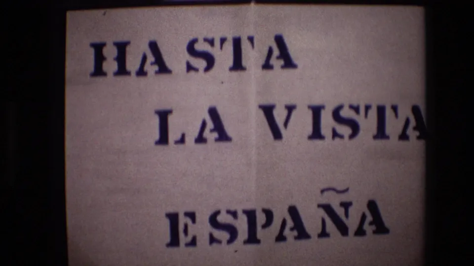 1972 8mm travel title card reading HASTA LA VISTA ESPAÑA in bold blue stencil-style lettering on a light paper background.