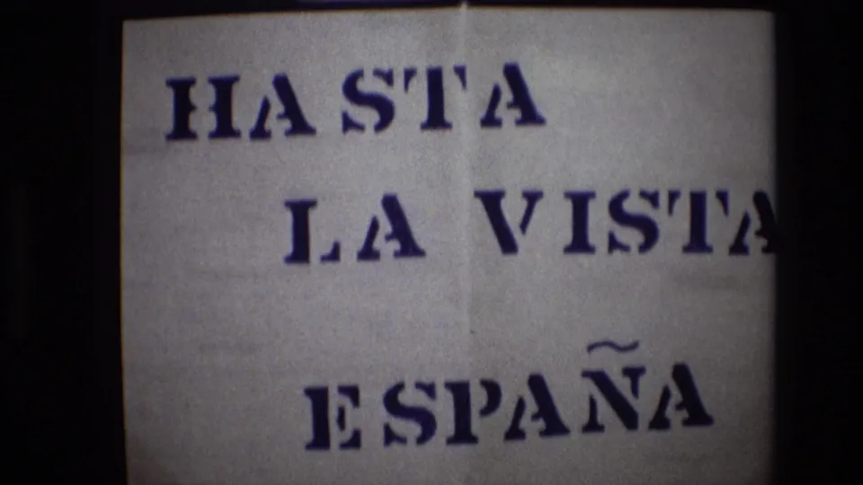 Portugal 1972 8mm frame of the “HASTA LA VISTA ESPAÑA” sign, with the phrase cropped at the right edge and dark vertical film borders visible.