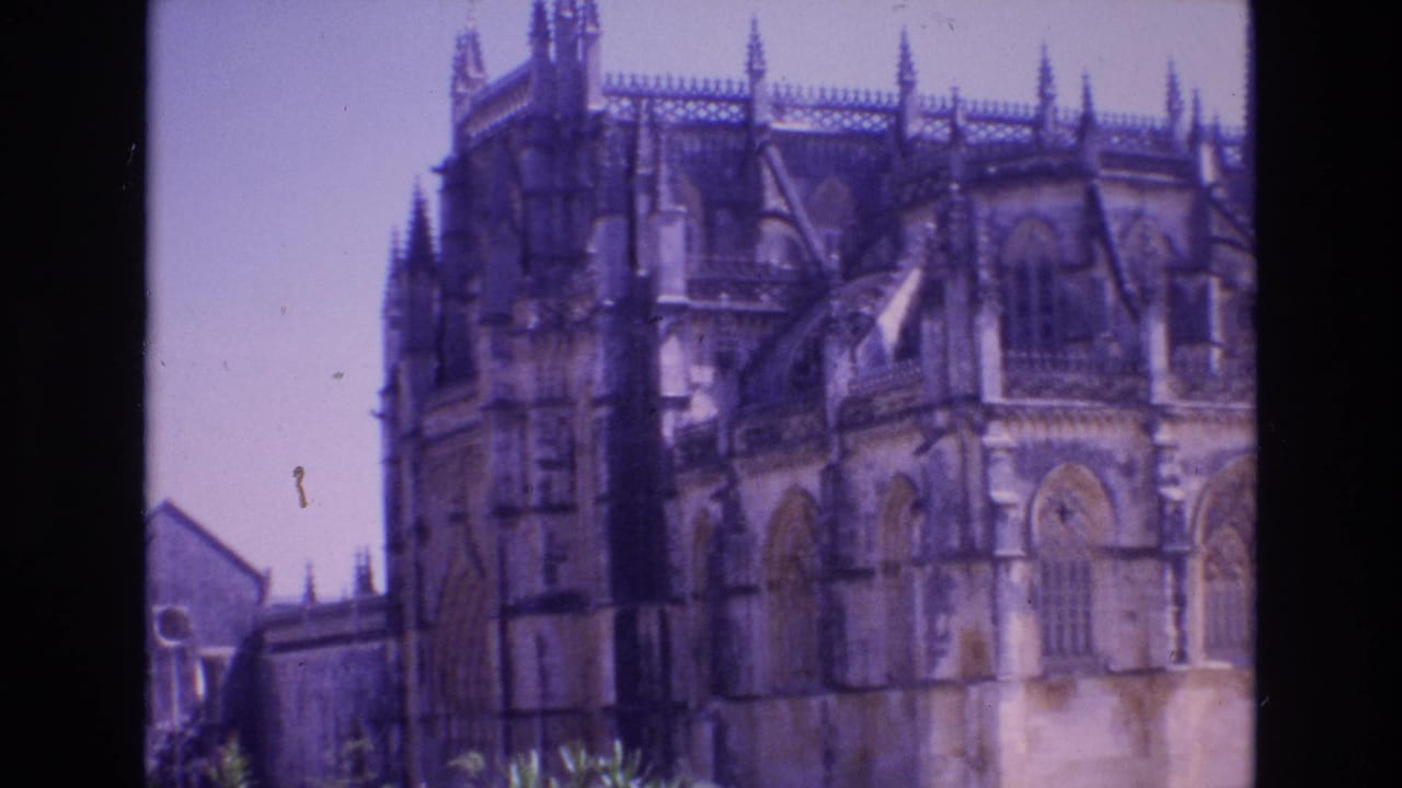 Church facade and spired roofline seen through a soft handheld frame.
