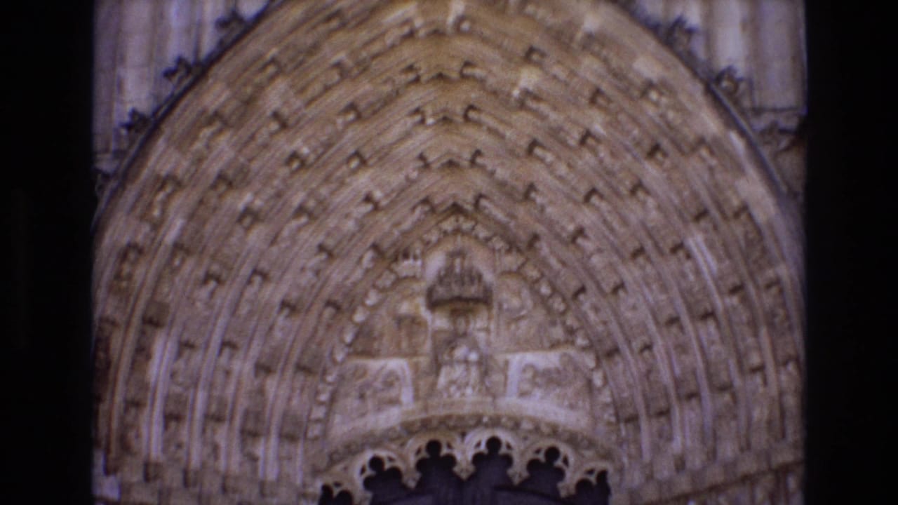 Upper portion of a carved stone church arch above a doorway.