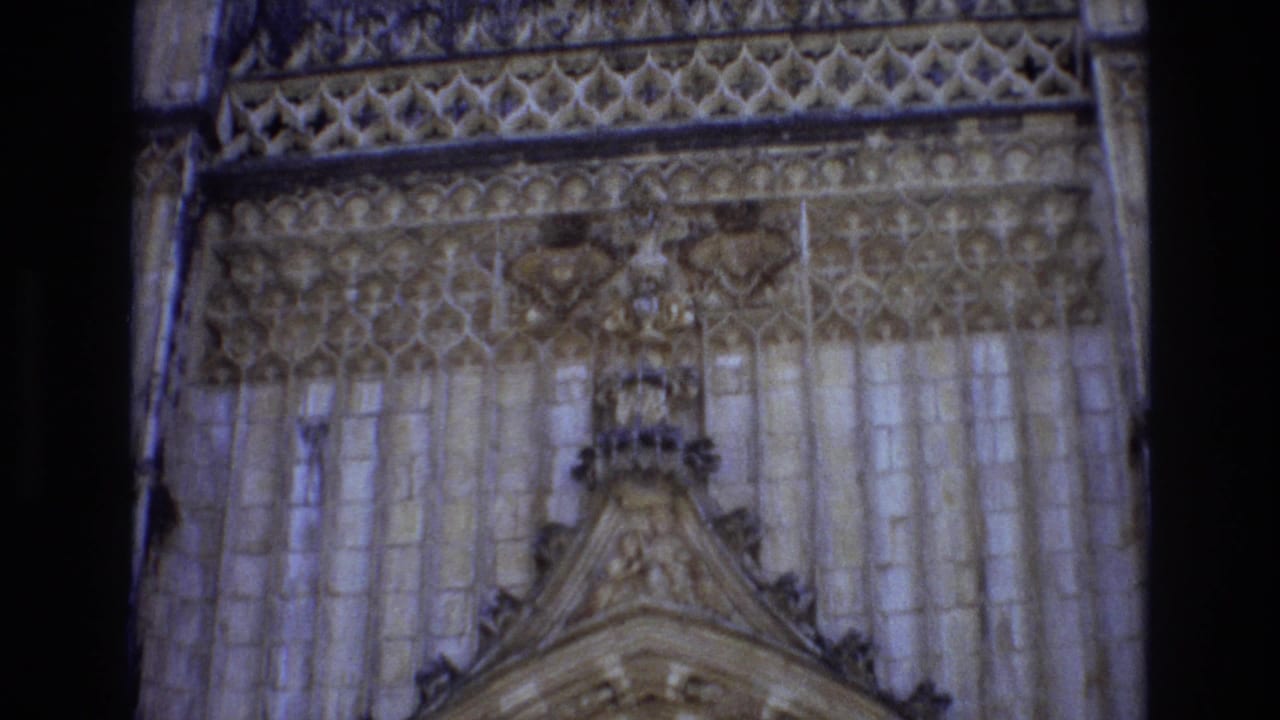 Upper cathedral facade with tracery and carved stone panels.