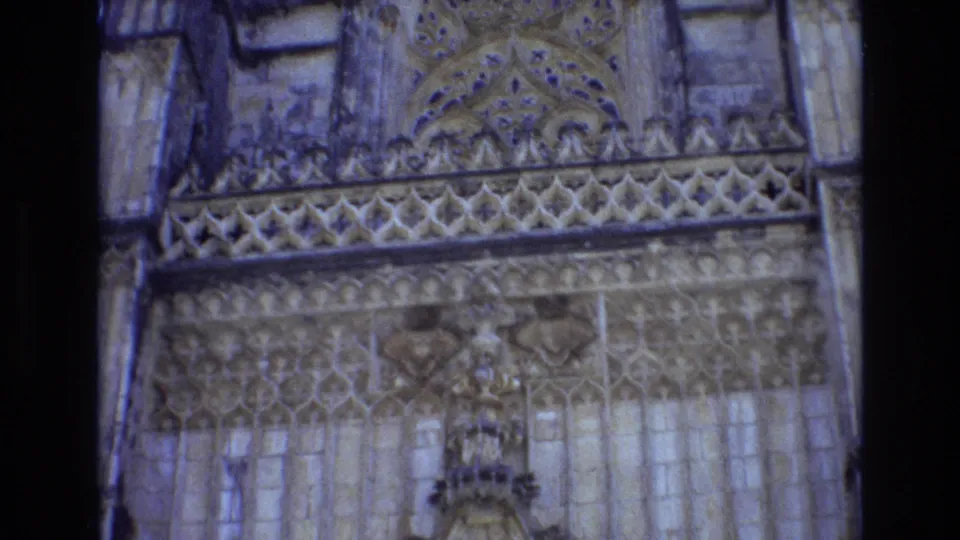 1972 Portugal 8mm frame showing detailed Gothic-style stone ornament, lattice carving, vertical masonry, and part of a pointed entrance arch.
