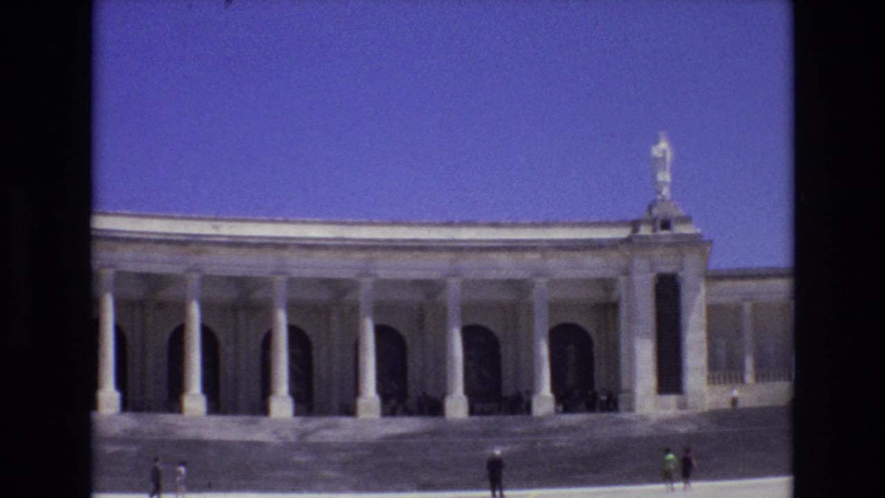 Closer view of the colonnaded facade with visitors scattered along the lower edge of the frame.