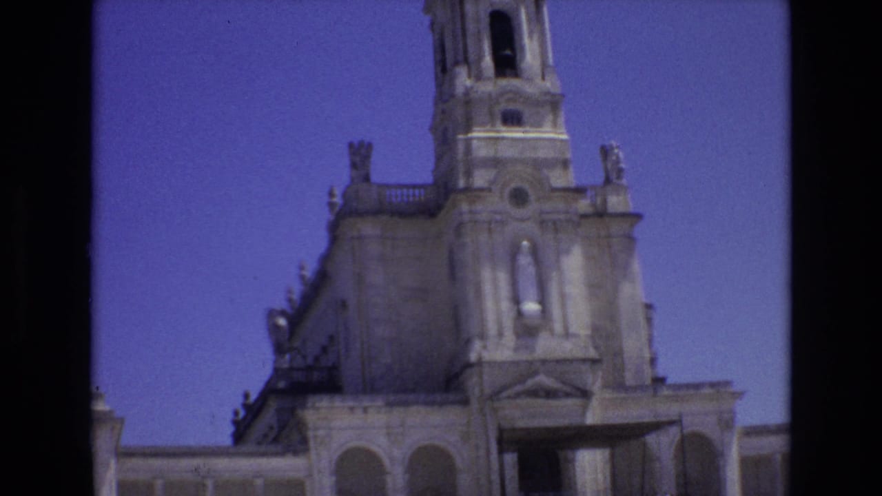 Closer view of the cathedral facade and bell tower against a blue sky.