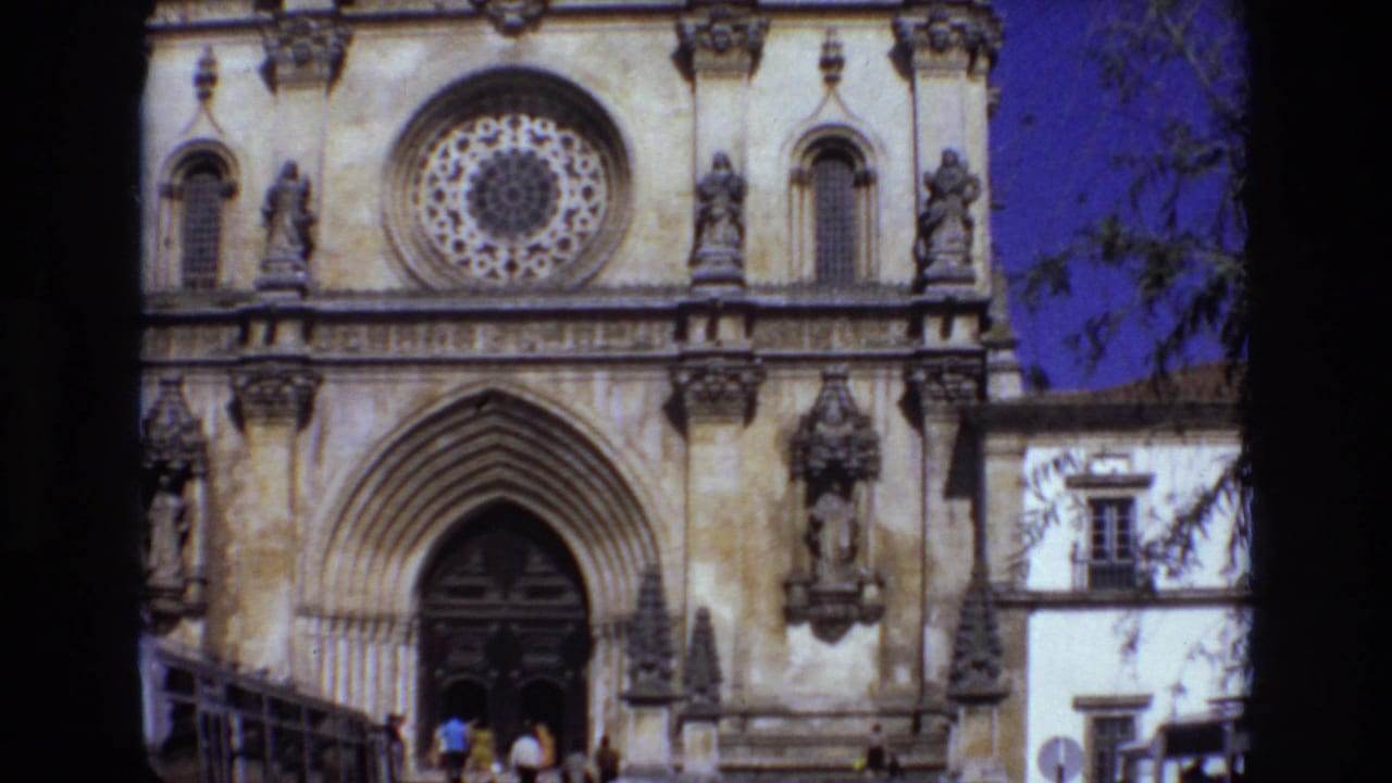 Church entrance and rose window with small figures near the doorway.