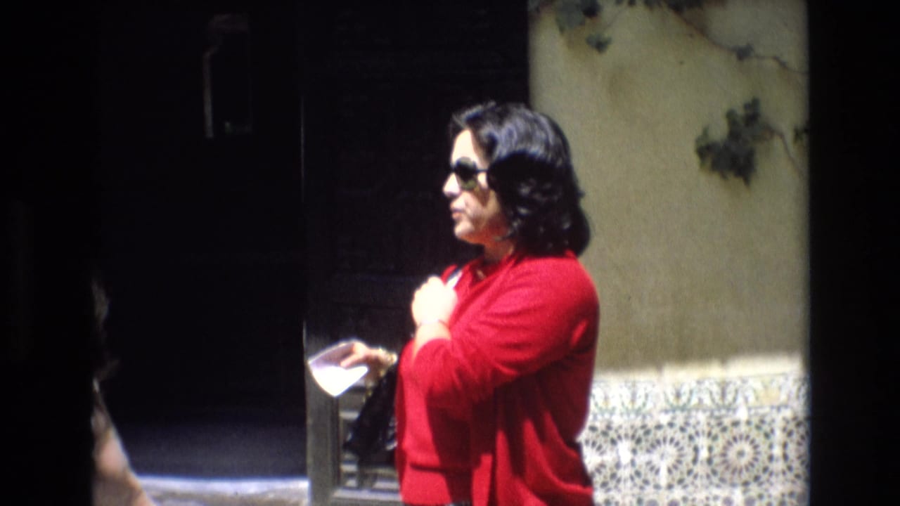 Woman in red sweater looks down at a small booklet near patterned wall tiles.