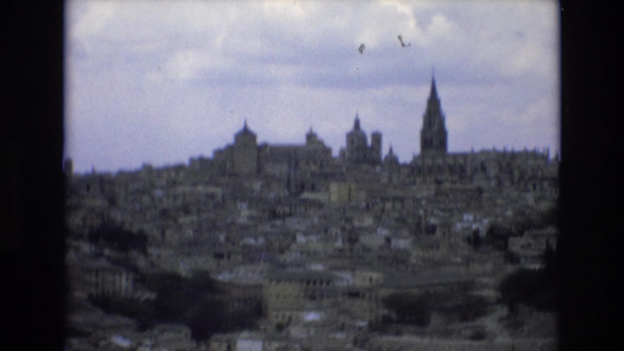 Wide city view with a prominent tall spire and several historic towers on the horizon.