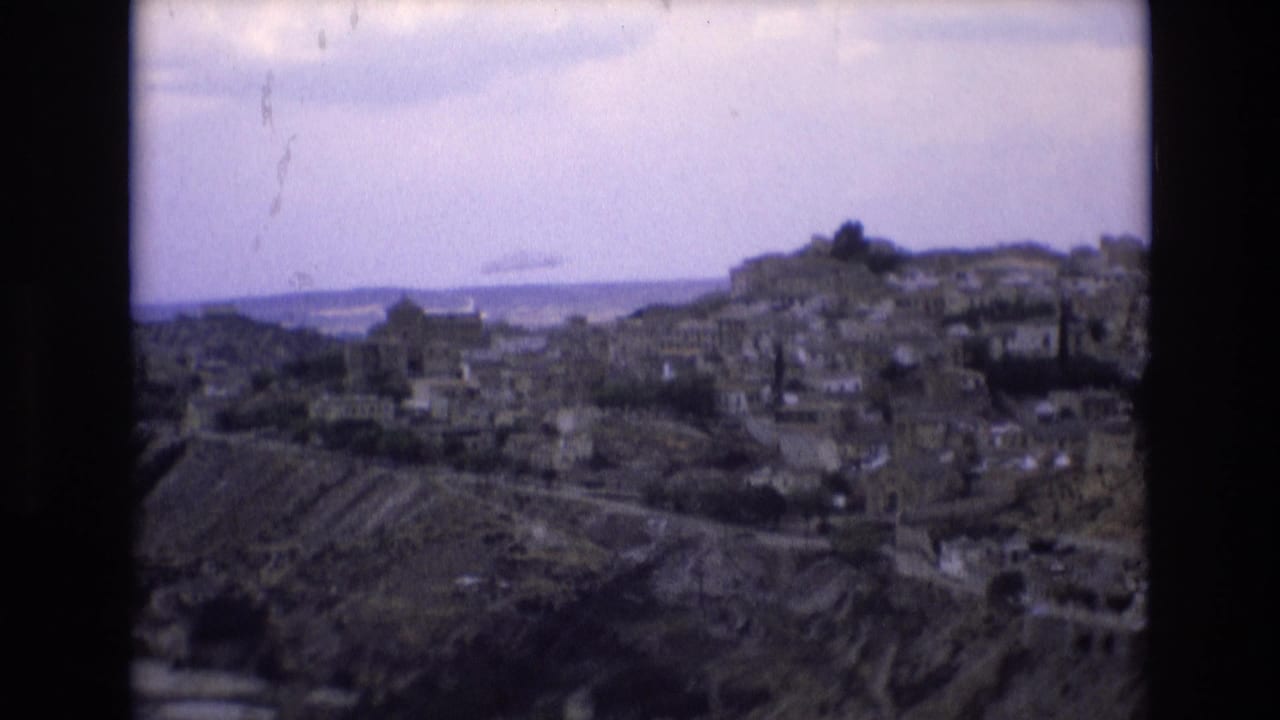 Panoramic view of a hill town with buildings and distant horizon.