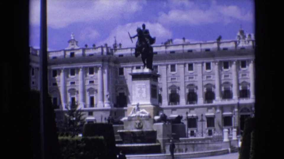 1972 Spain frame with a monumental palace facade and equestrian statue, seen from a visitor viewpoint with dark gate or scan edges around the image.