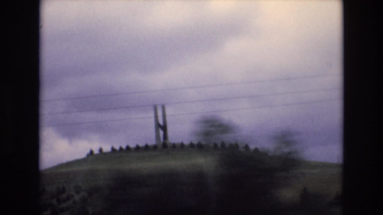 Closer blurred view of the hilltop structure and ridge with power lines overhead.