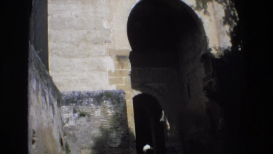 The final frame shows a partially shadowed stone archway and adjacent masonry, continuing the 1972 Spain travel view from the same home-movie clip.