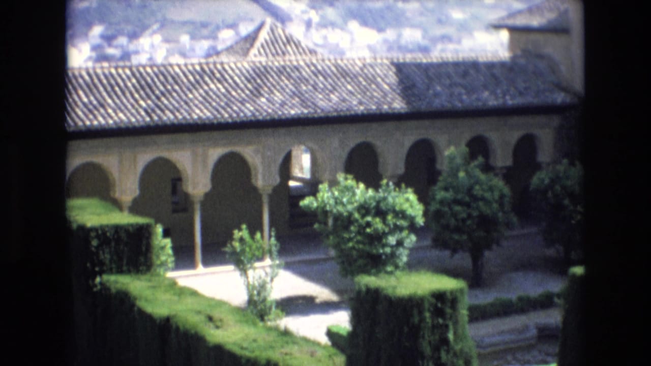 Formal garden and long arcade with horseshoe arches viewed from above.