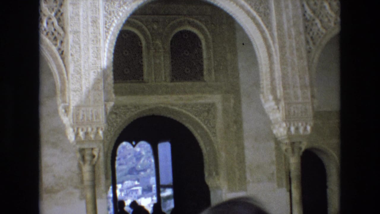 Decorated archway with dark opening and bright exterior view beyond.