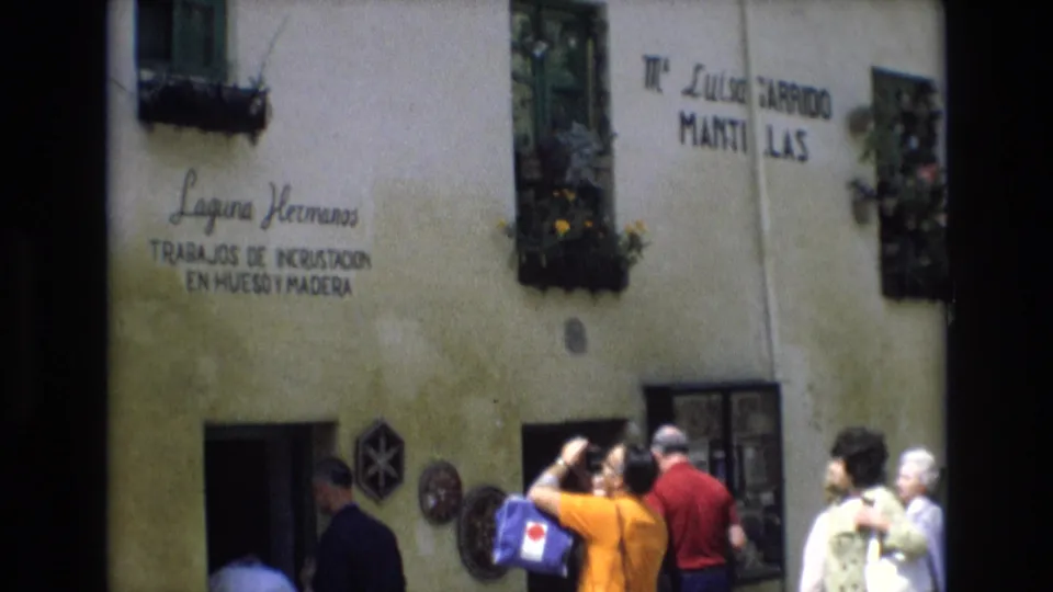 A 1972 Spain home-movie frame shows tourists outside the Laguna Hermanos facade, with one visitor photographing the Spanish signage and wall decorations.