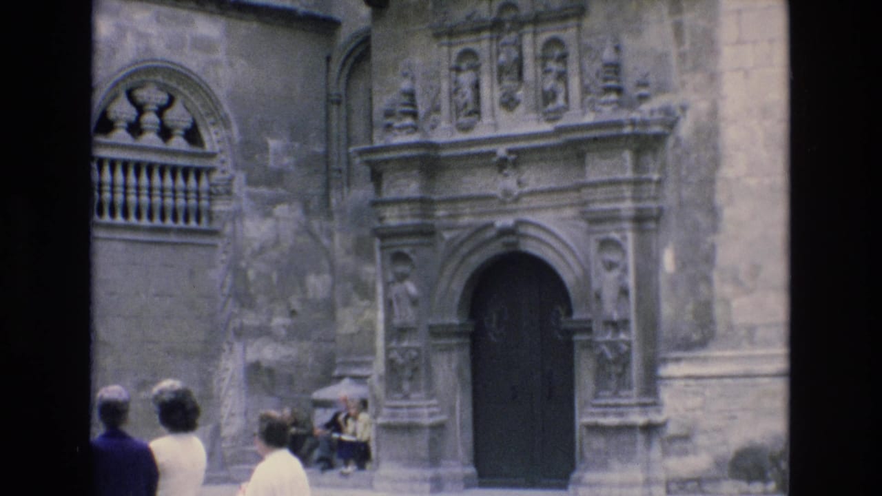 Visitors look toward a carved arched doorway and stone balcony details.