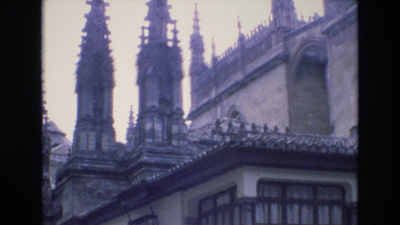 1972 Spain 8mm frame showing ornate Gothic cathedral spires above a traditional white stucco building with tiled roof and dark window framing.