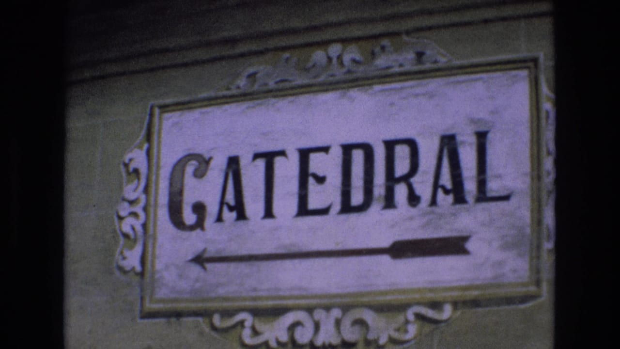 1972 Spain 8mm frame showing a weathered ornamental sign reading CATEDRAL with a left-pointing arrow on a wall.