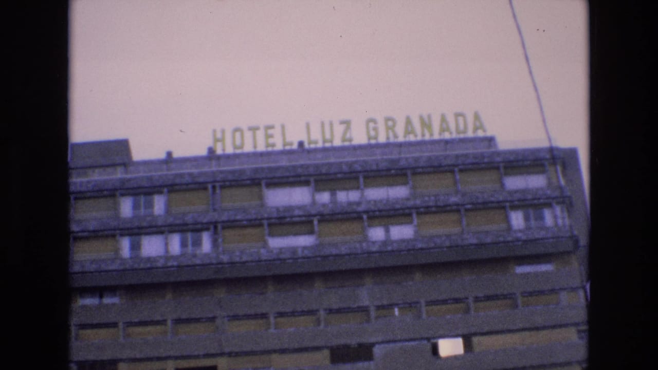 Rooftop hotel sign and upper stories of Hotel Luz Granada.